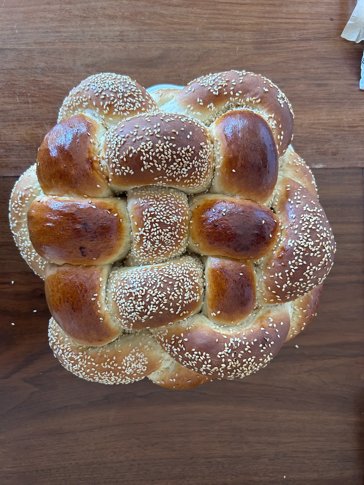Chaim's signature woven round challah, golden and sprinkled with sesame
